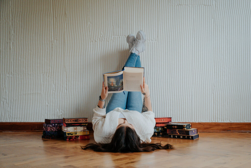 Kobieta otoczona książkami podczas sesji wizerunkowej w Studio LaCasa